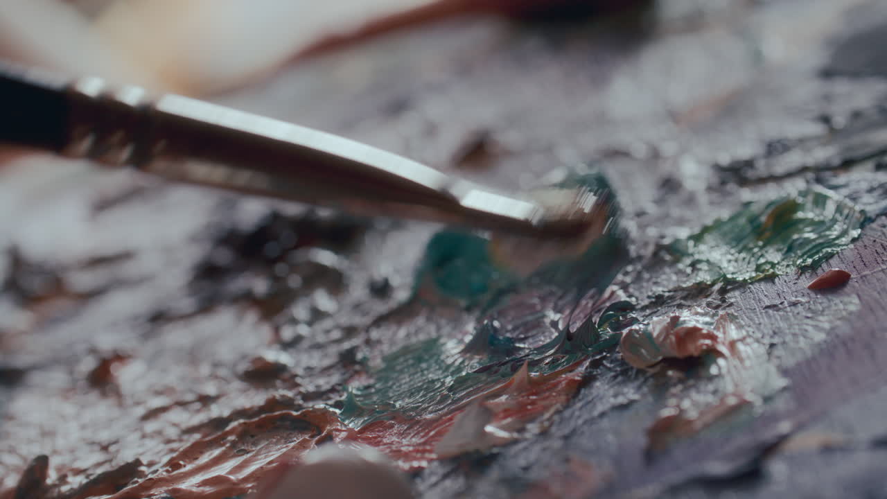 Primissimo piano sulla miscelazione di pittura ad olio su tavolozza con pennello.