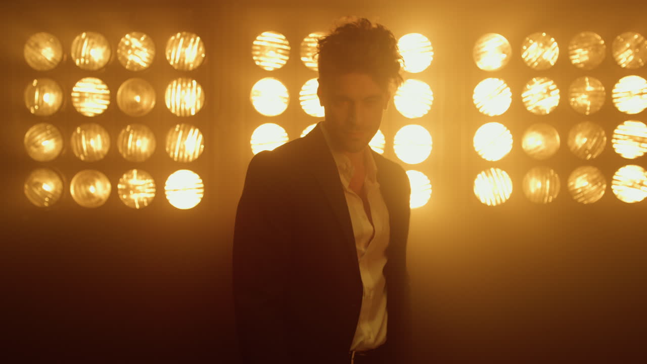 남자 모델이 나이트클럽에서 패션 옷을 입고 자신감을 보여주고 있습니다.