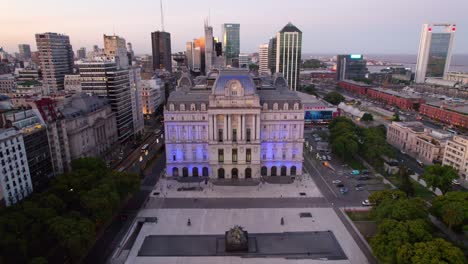 dolly en vista aérea del frente del centro cultural kirchner iluminado con luces azules, ciudad de noche durante la hora azul, buenos aires, argentina