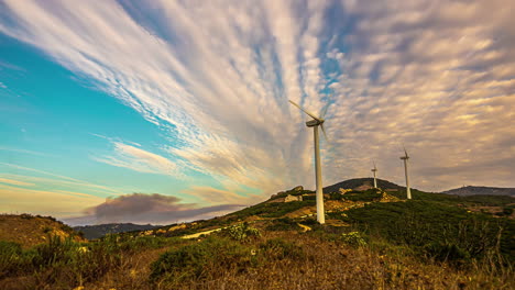 a time lapse shot of wind turbines on a mountainous landscape and a cloudscape