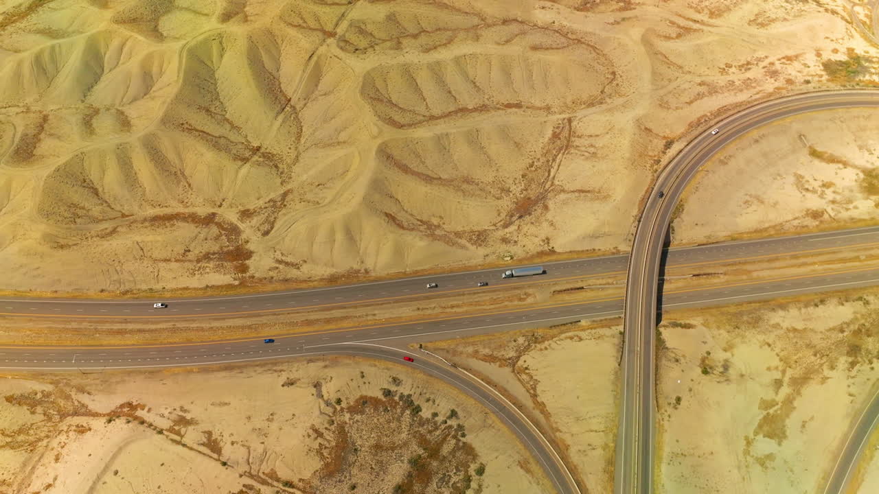 Sandy dunes crossed by the quick highways. Cars going fast by the roads of Colorado, USA. Aerial view.
