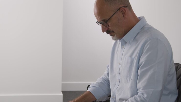 Close Up Of Mature Man Sitting In Reception Chair For Appointment In Surgery Or Hospital Waiting Room Or Job Interview 2