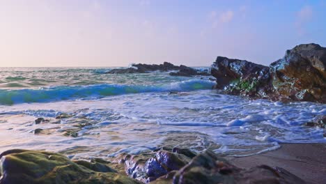 olas del mar rompiendo en una playa de arena y rocas
