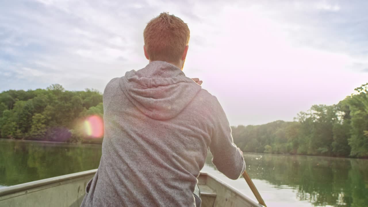 Man paddles boat on calm water