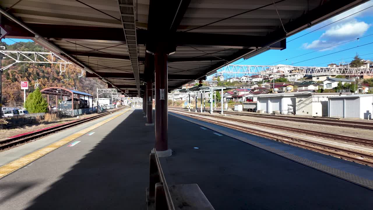 Empty platform at Kiso Fukushima Station showing surrounding mountains and buildings