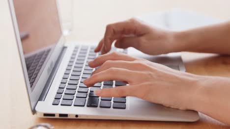 mujer de negocios trabajando en una computadora portátil en su escritorio