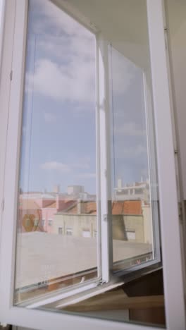 ventana abierta con vista a la ciudad