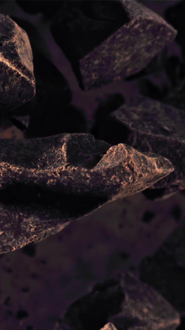 Primo piano astratto di rocce scure e texturizzate e particelle fluttuanti.