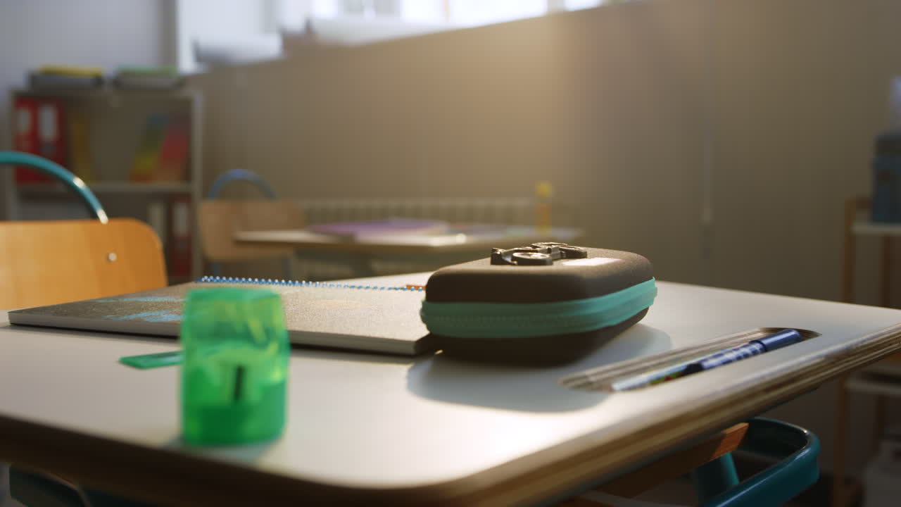 школьные принадлежности на столе в классе. блокнот и ручки лежат на столе