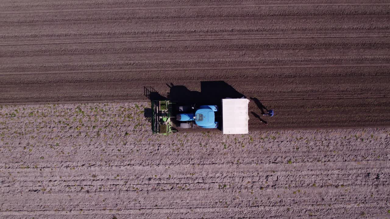 Vista aerea di Obdam con un trattore, campi coltivati e un prato, che mostra un paesaggio rurale aperto nei Paesi Bassi.