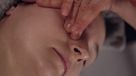 cosmetology therapist making woman relaxing spa face massage with hands at salon, detox and healing