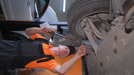 mechanic working on the undercarriage of a car in a repair shop