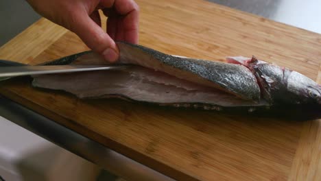 chef cutting into back fish