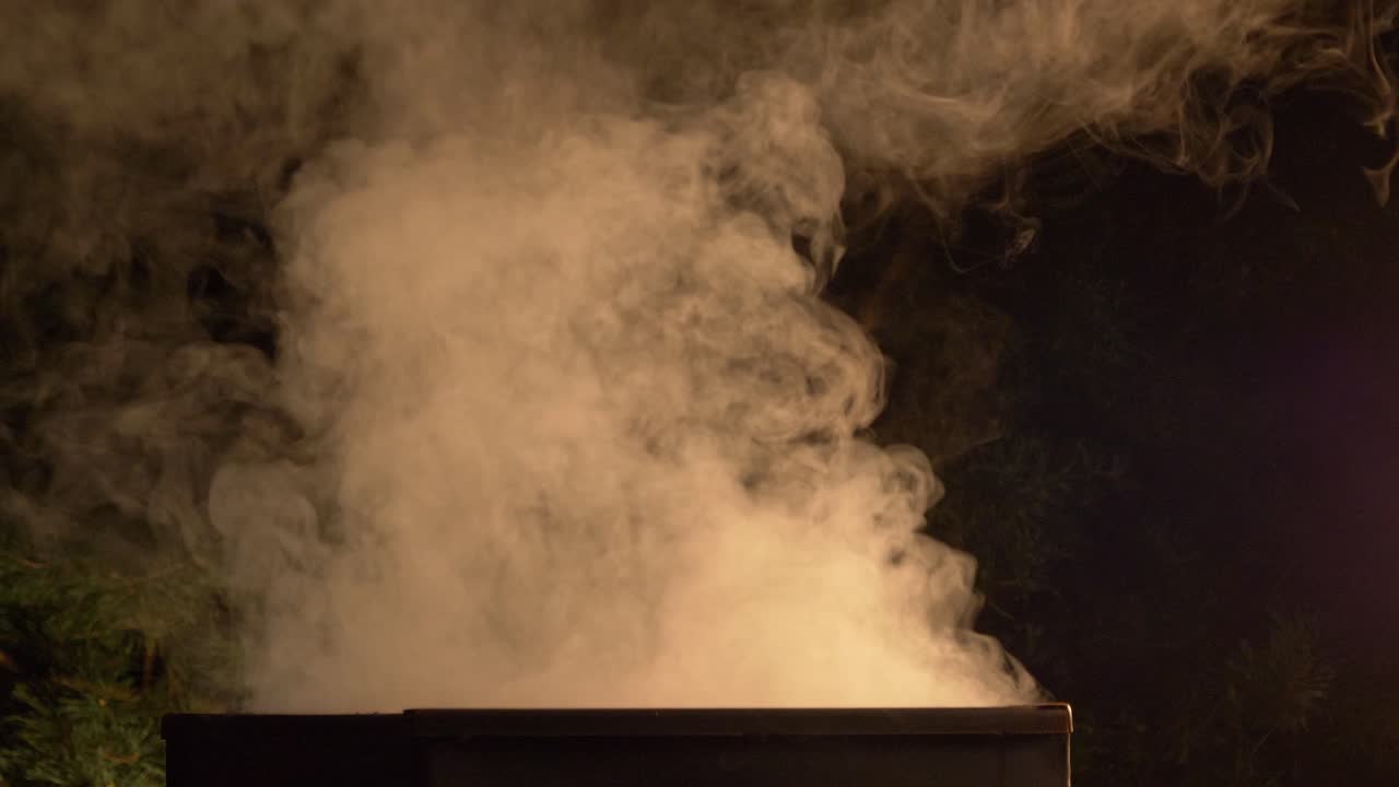 한 사람이 숯불 그릴에서 뚜껑을 제거하고 폴란드 자고로프 아렌델에서 요리된 훈제 생선을 꺼냅니다.