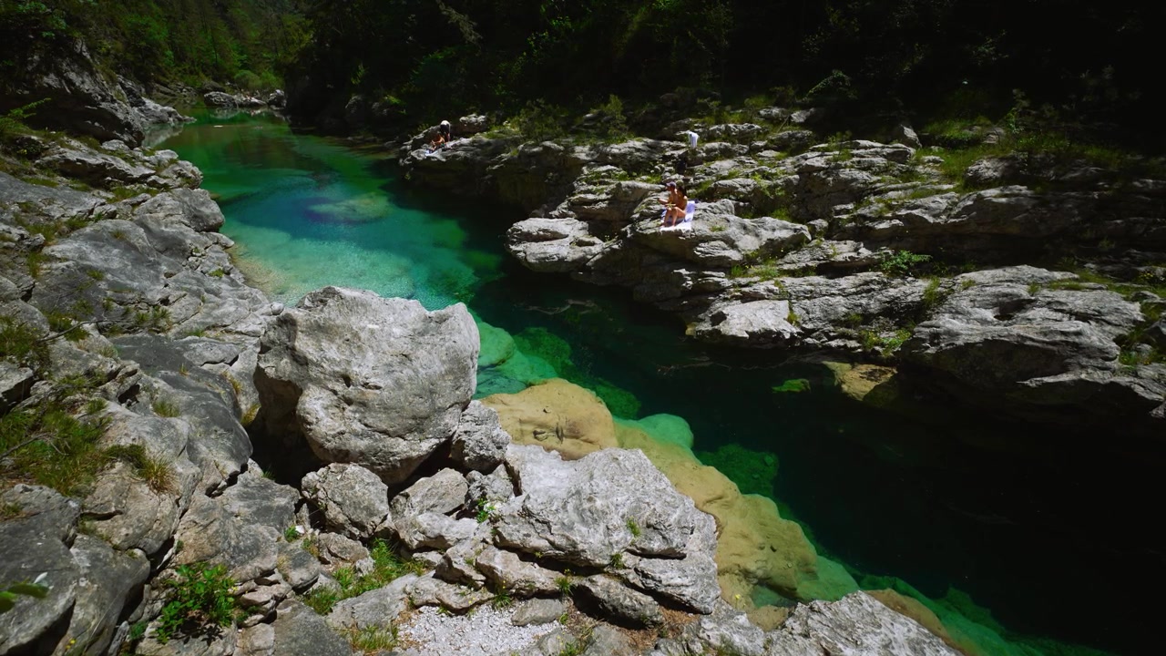 Piscina naturale con imponenti massi bianchi e turisti in vacanza che si rilassano alle Pozze Smeraldine.