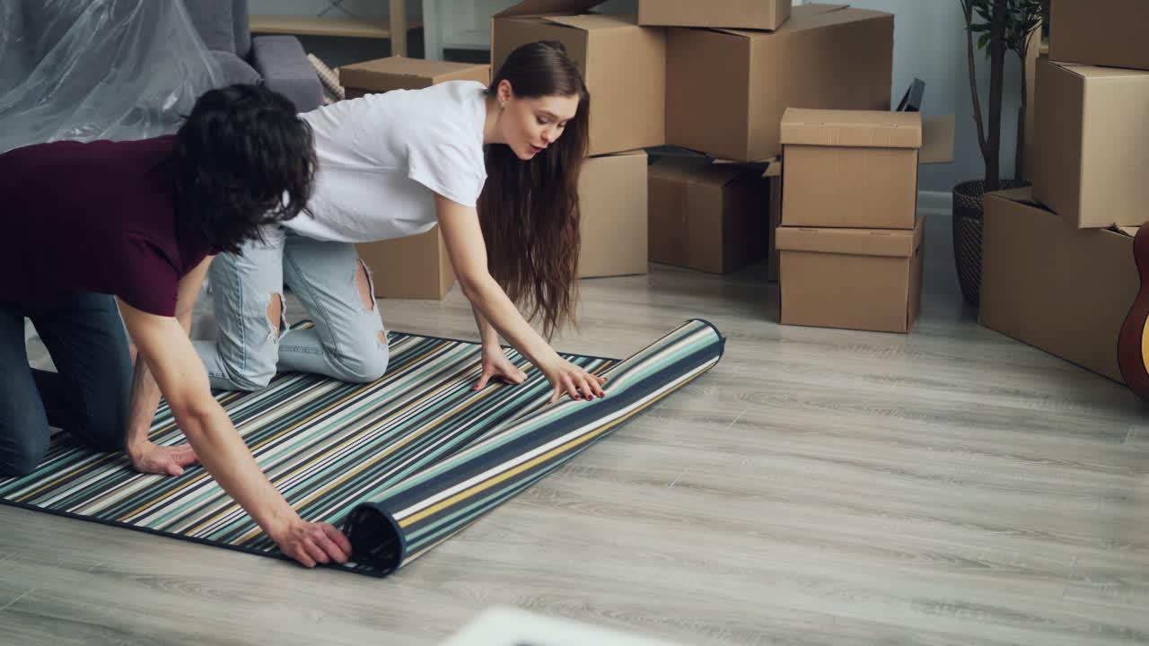 Couple Unrolling Carpet in New Home