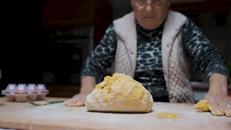 mujer de edad amasar la masa en la cocina