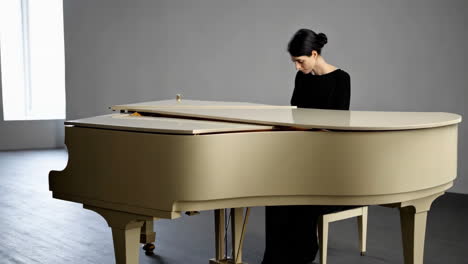 a woman playing a grand piano