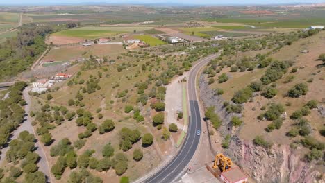 a car traveling along the road built on top of the enormous Alange dam wall