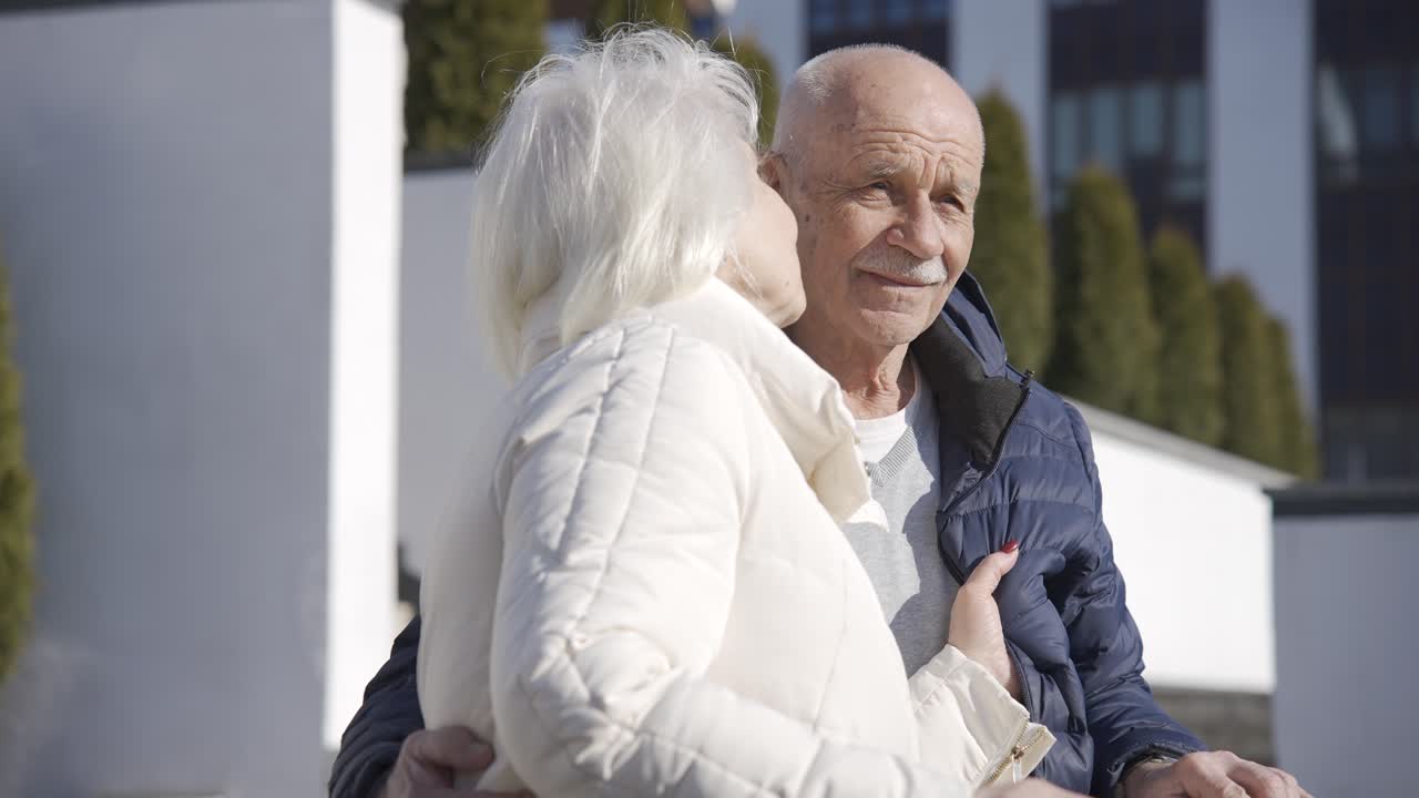 겨울날 공원에서 이야기하고 키스하는 노인 부부