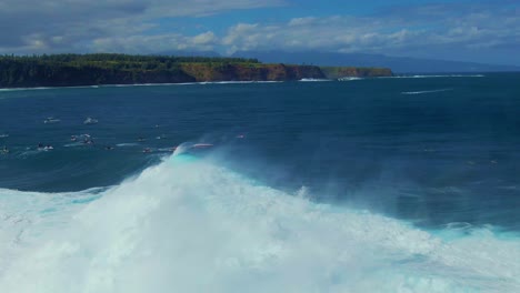 surfer catching big rolling ocean wave and riding through white sparkling foaming water in hawaii