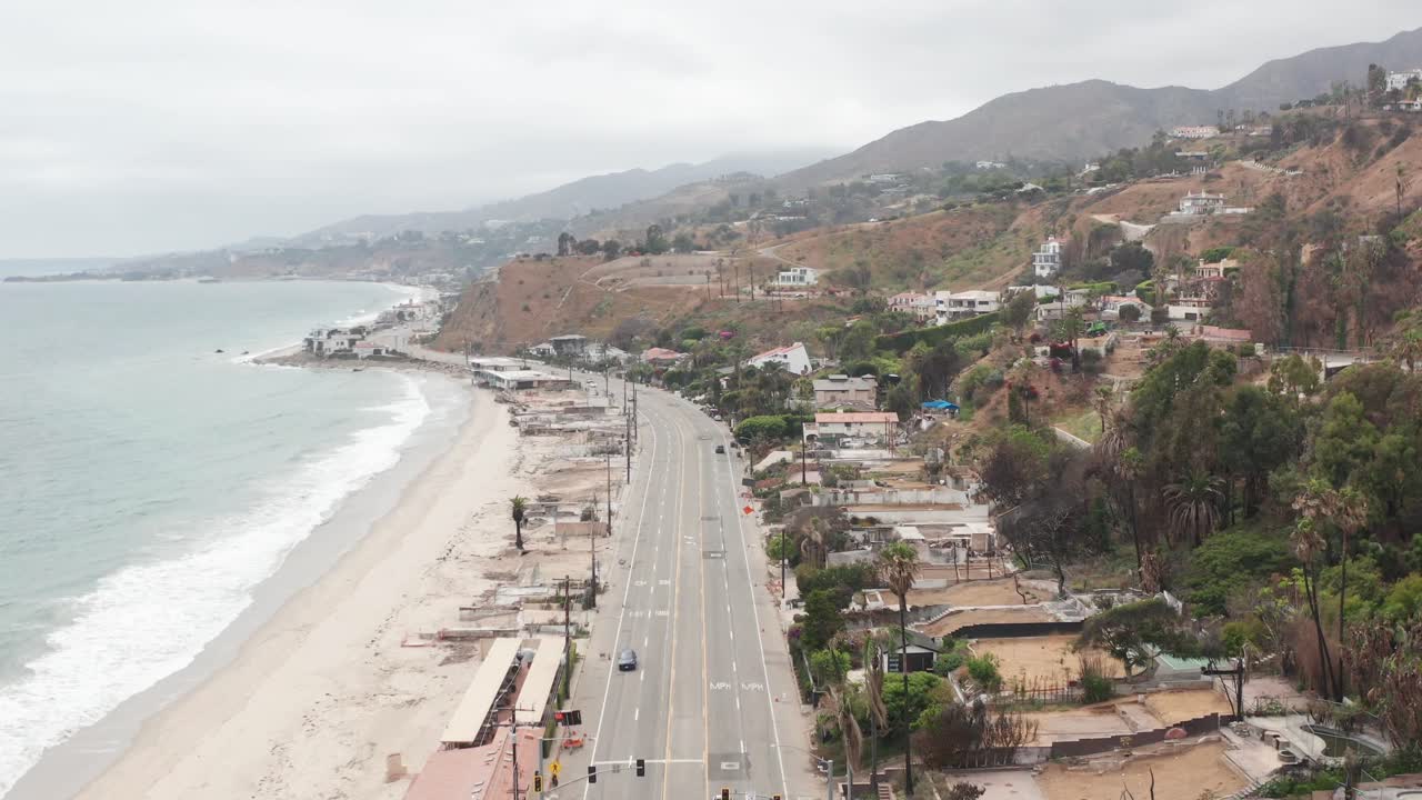 Aerial wide tilting up shot of the Pacific Coast Highway at Las Flores Canyon in Malibu after the wildfire in Los Angeles, California. 4K