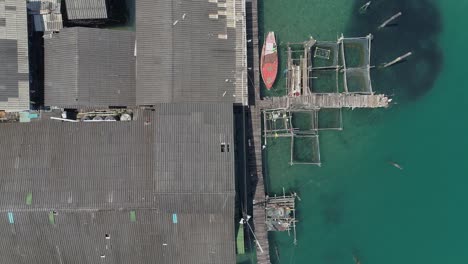 vista aérea de una aldea tropical frente al mar con un barco de pesca