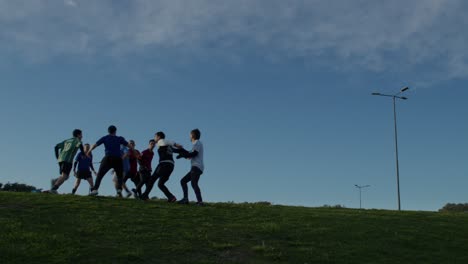 a group of friends playing football soccer on a grassy field under a clear sky, enjoying an outdoor game
