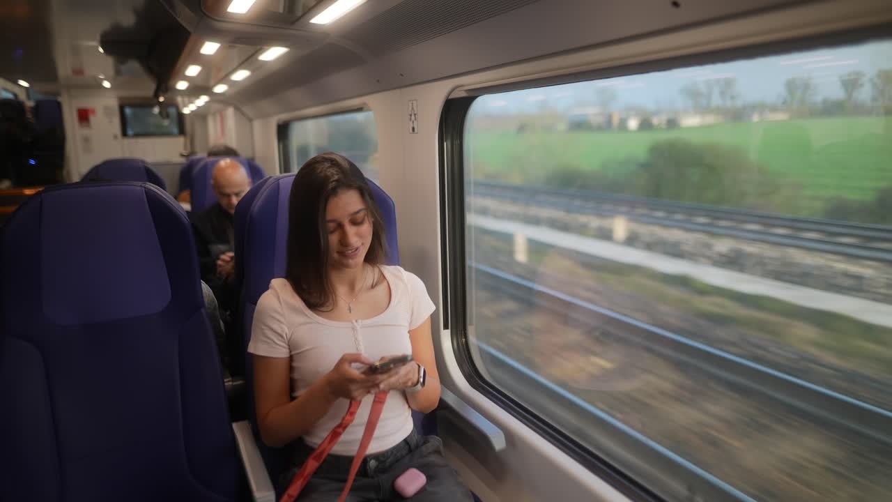 기차에서 스마트폰을 사용하는 여성