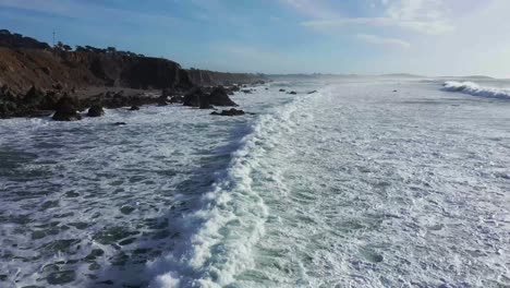 Drone-Sobrevuelo-Bajo-De-Las-Olas-Del-Océano-En-Un-Día-Soleado