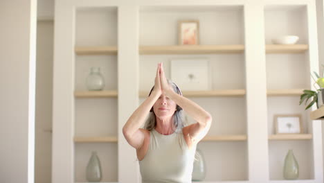 mature caucasian woman practicing yoga at home