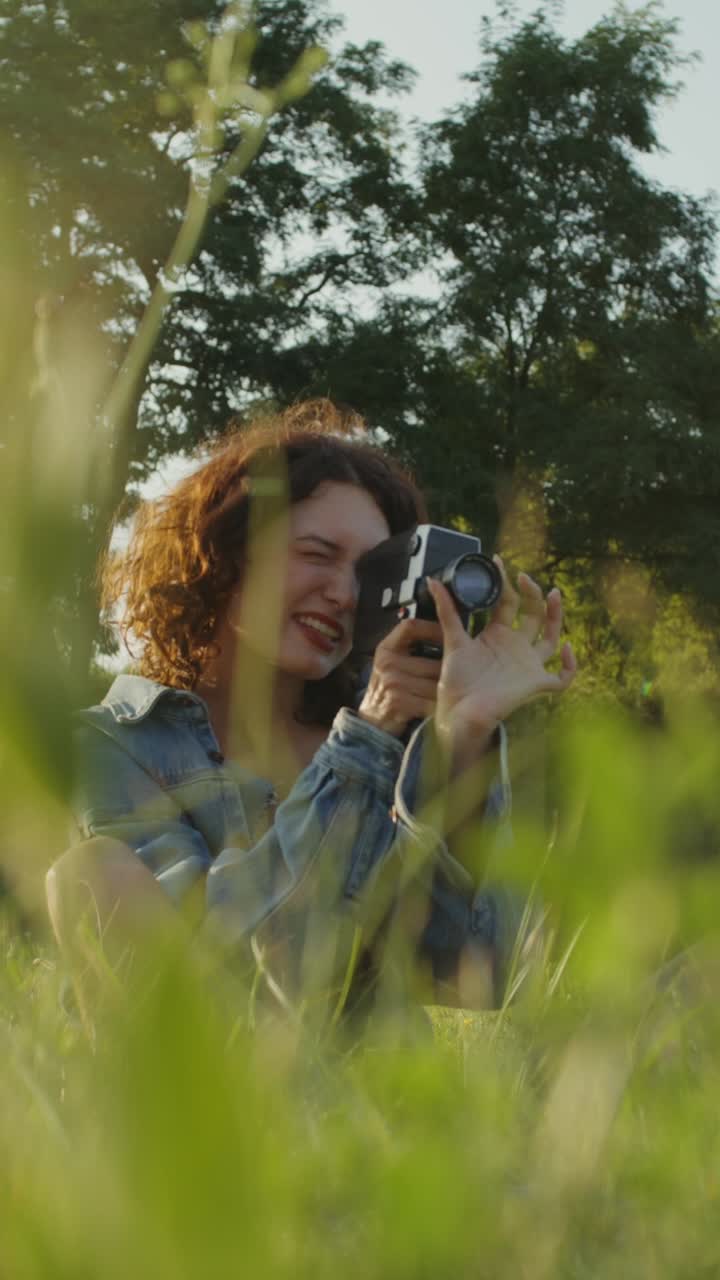 Donna che scatta foto con una macchina fotografica vintage in un parco