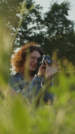 woman taking pictures with a vintage camera in a park