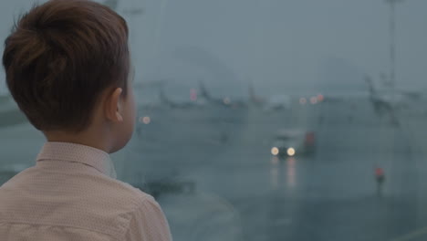 child is attracted with airport view in the window