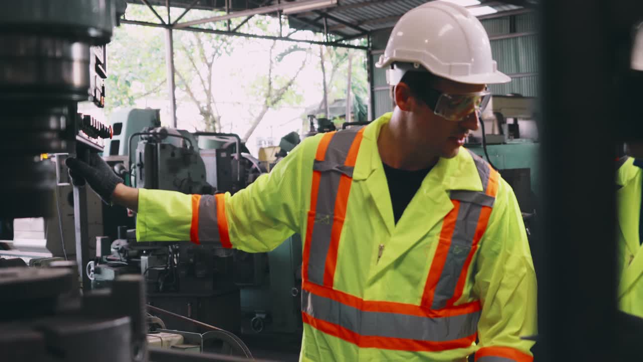 Group of factory workers using machine equipment in factory workshop