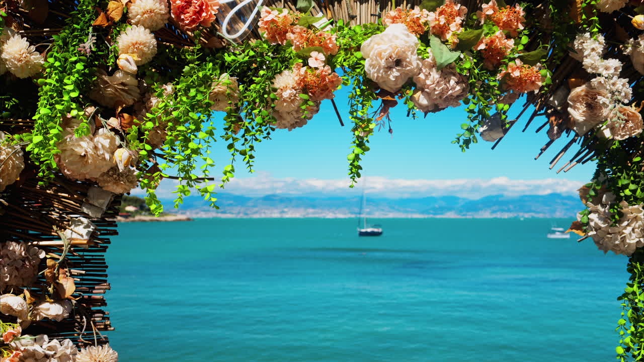 Close up of an orange flower arrangement with the blue sea on the background
