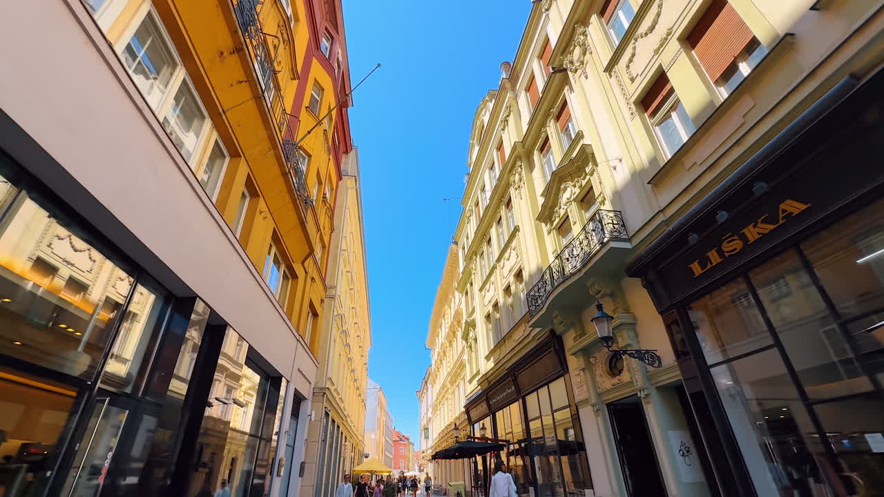 Facades of the four-storied old buildings along the lovely street. Low angle view. Stroll by the old town of Bratislava, Slovakia