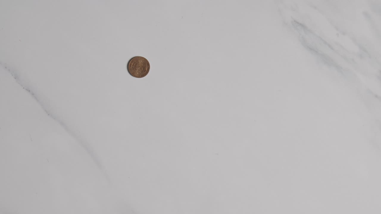 disparo aéreo de moneda de una mano agarrando una pila de billetes y monedas de euro en una superficie de mármol