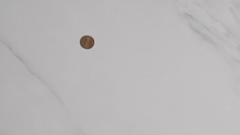 overhead currency shot of hand grabbing pile of euro notes and coins on marble surface