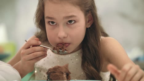 초콜릿 케이크를 먹는 예쁜 소녀. 생일 케이크를 먹는 아이의 초상화