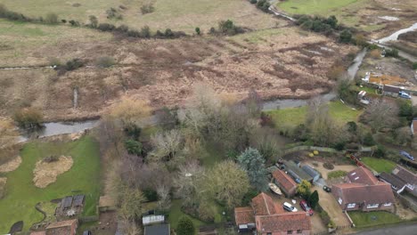 Drone-Shot-of-River-Nar-and-Houses-at-Castle-Acre-Priory,-Norfolk,-England