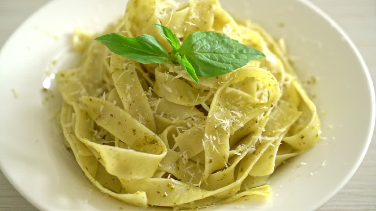 pasta fettuccine al pesto con queso parmesano encima - estilo de comida italiana