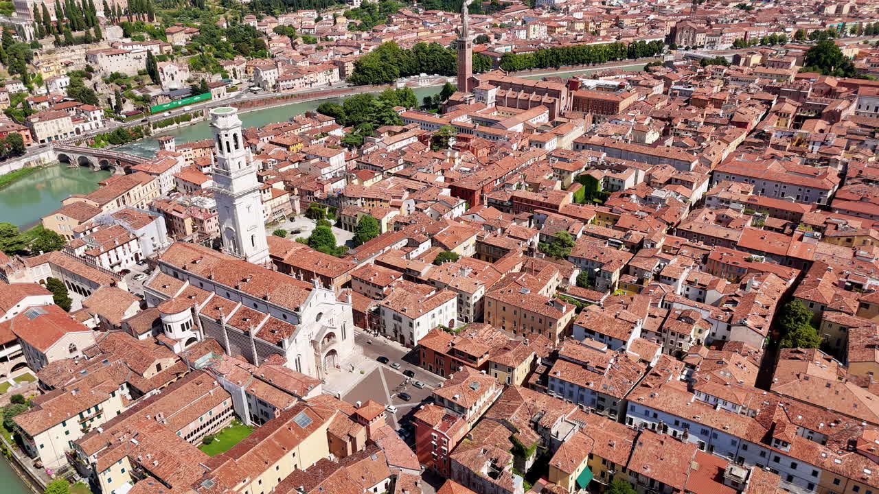 Aerial drone view of Verona's medieval cityscape featuring Verona Cathedral and historic rooftops with the Adige River flowing through the city