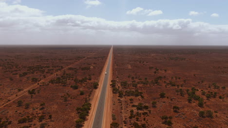 Aerial-drone-panning-shot-of-a-campervan-on-empty-road-in-the-Outback