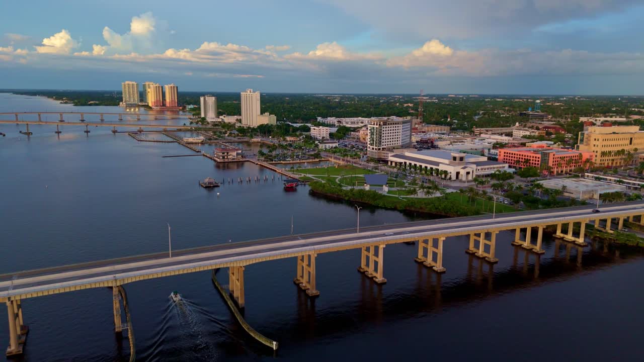 Aerial establishing shot of cars on Caloosahatchee Bridge crossing river. Sunset time in fort Myers city, Florida. Wide shot