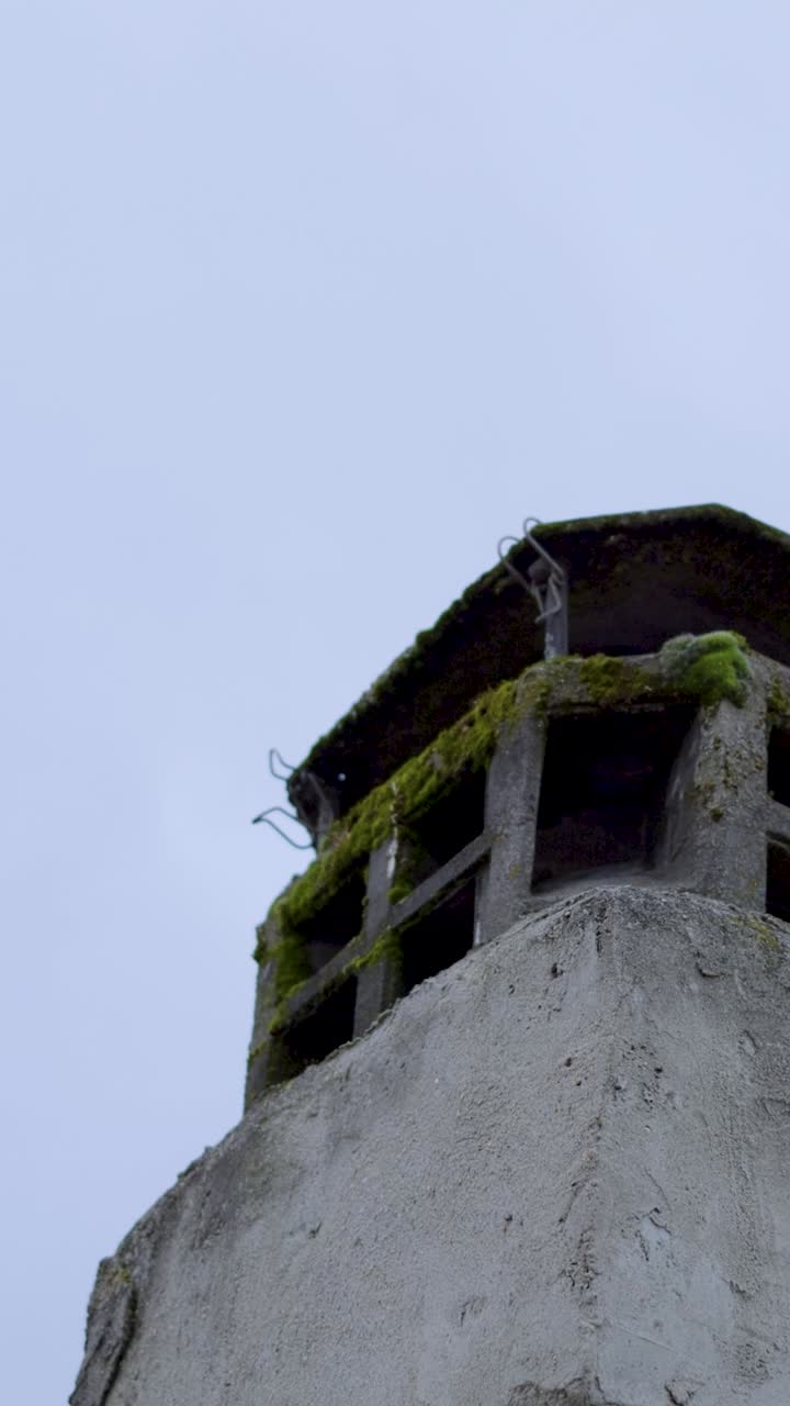 Old chimney with moss under cloudy sky, a symbol of decay and time