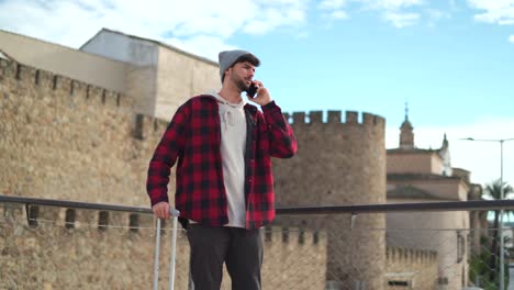 Serious-man-having-phone-call-near-medieval-building