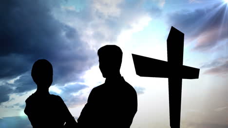 animation of silhouette of couple over clouds and cross