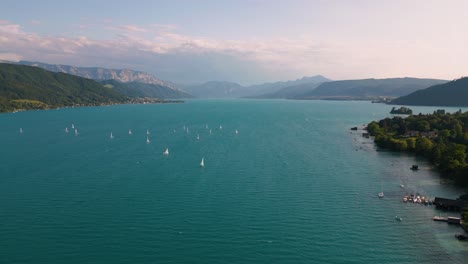 Blue-lake-Attersee-in-Austria-with-sailing-ship-boat,-clear-water-and-alps-mountains-near-idyllic-scenic-Wolfgangsee,-Mondsee-close-to-famous-Mozart-city-Salzburg