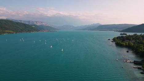 blue lake attersee in austria with sailing ship boat, clear water and alps mountains near idyllic scenic wolfgangsee, mondsee close to famous mozart city salzburg